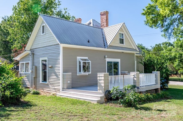 328 E Center Ave, Mooresville, NC 28115 - back of house featuring a chimney, a deck, a yard, and metal roof