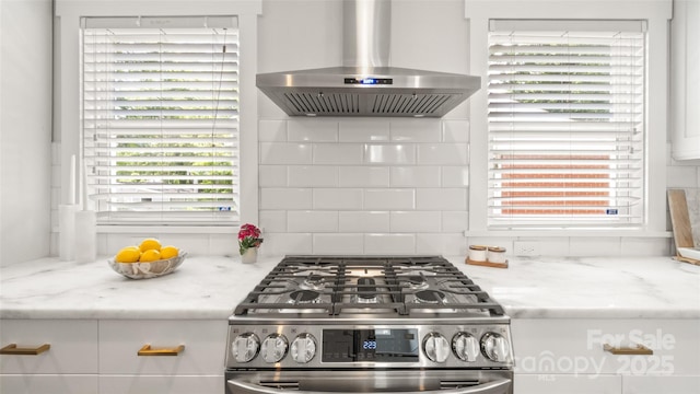 1446 Downs Ave, Charlotte, NC 28205 - kitchen featuring stainless steel gas range oven, wall chimney exhaust hood, plenty of natural light, and white cabinetry
