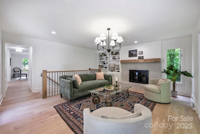 9520 Squirrel Hollow Ln, Charlotte, NC 28270 - living area featuring light wood-style floors, plenty of natural light, a chandelier, a glass covered fireplace, and recessed lighting