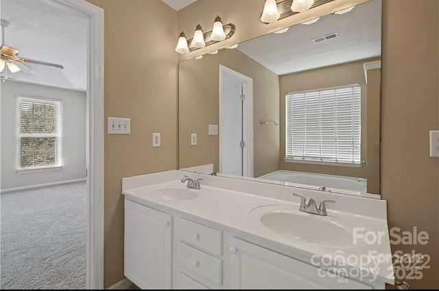 bathroom featuring double vanity, a ceiling fan, and a bath