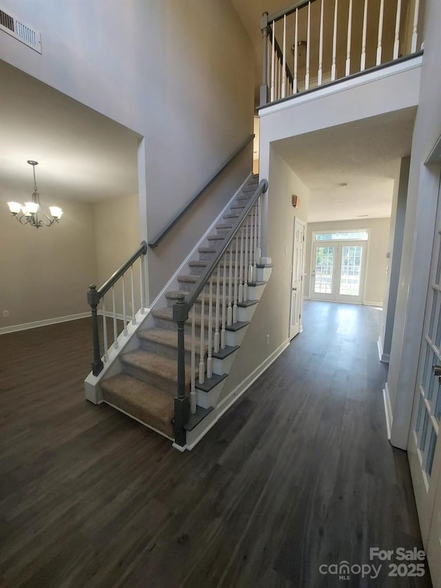 6614 Truman St, Indian Trail, NC 28079 - stairs featuring baseboards, wood finished floors, a chandelier, and a high ceiling