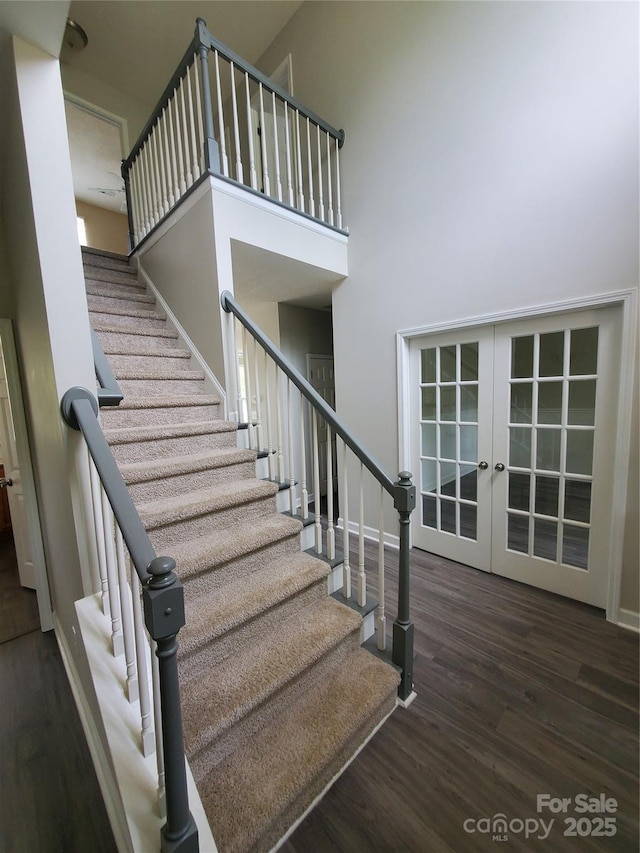 6614 Truman St, Indian Trail, NC 28079 - staircase with french doors, wood finished floors, baseboards, and a towering ceiling