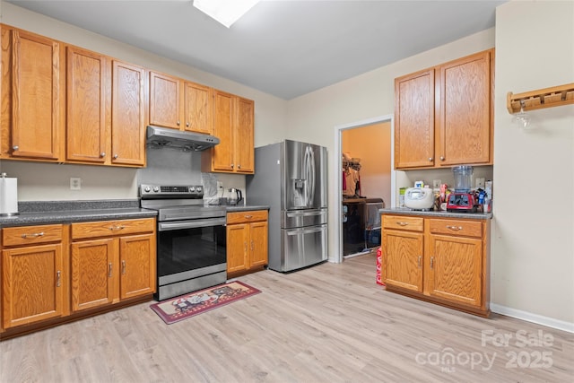 1911 Savannah Hills Dr, Matthews, NC 28105 - kitchen with appliances with stainless steel finishes, under cabinet range hood, light wood finished floors, dark countertops, and brown cabinetry
