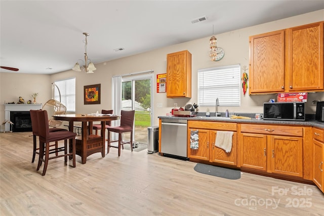 1911 Savannah Hills Dr, Matthews, NC 28105 - kitchen featuring stainless steel dishwasher, black microwave, a sink, light wood-style flooring, and pendant lighting