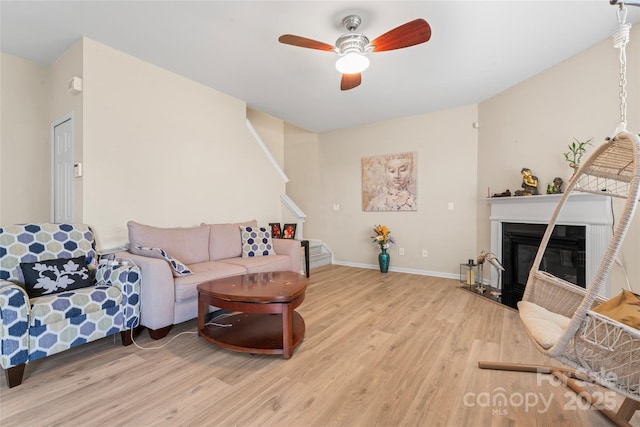 1911 Savannah Hills Dr, Matthews, NC 28105 - living area featuring wood finished floors, ceiling fan, stairway, a glass covered fireplace, and baseboards