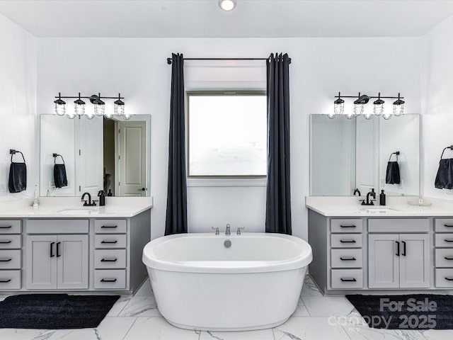 121 Enclave Meadows Ln, Matthews, NC 28104 - bathroom featuring marble finish flooring, two vanities, a freestanding tub, and recessed lighting