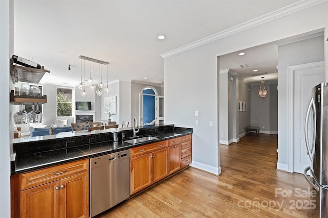 229 N Church St Unit 204, Charlotte, NC 28202 - kitchen featuring appliances with stainless steel finishes, a sink, ornamental molding, a fireplace, and brown cabinets