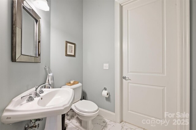 229 N Church St Unit 204, Charlotte, NC 28202 - bathroom featuring marble finish flooring, toilet, baseboards, and a sink