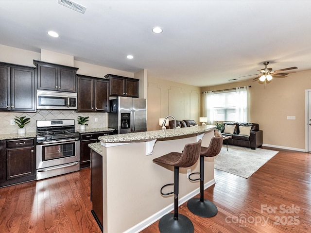 7325 Overmountain Dr, Rock Hill, SC 29732 - kitchen featuring stainless steel appliances, a breakfast bar area, open floor plan, an island with sink, and dark wood-style floors