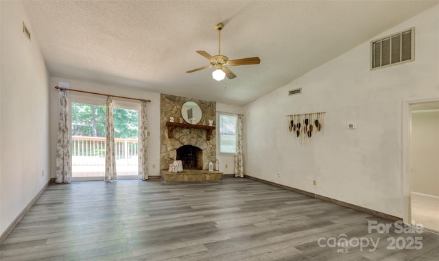 2011 20th Street Pl NE, Hickory, NC 28601 - unfurnished living room featuring ceiling fan, wood finished floors, a textured ceiling, a stone fireplace, and baseboards