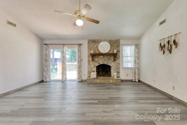 2011 20th Street Pl NE, Hickory, NC 28601 - unfurnished living room with a textured ceiling, wood finished floors, a fireplace, a ceiling fan, and baseboards