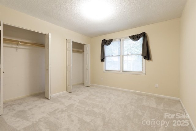 2011 20th Street Pl NE, Hickory, NC 28601 - unfurnished bedroom featuring two closets, carpet flooring, and a textured ceiling
