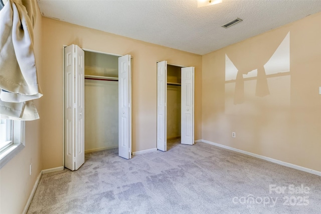 2011 20th Street Pl NE, Hickory, NC 28601 - unfurnished bedroom with multiple closets, carpet, a textured ceiling, and baseboards