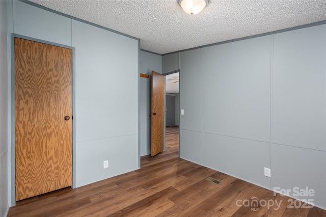 376 Puzzle Creek Rd, Bostic, NC 28018 - unfurnished bedroom with wood finished floors, a textured ceiling, and a decorative wall