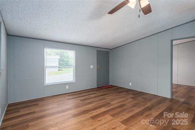 376 Puzzle Creek Rd, Bostic, NC 28018 - unfurnished bedroom featuring wood finished floors, a textured ceiling, a ceiling fan, and a decorative wall