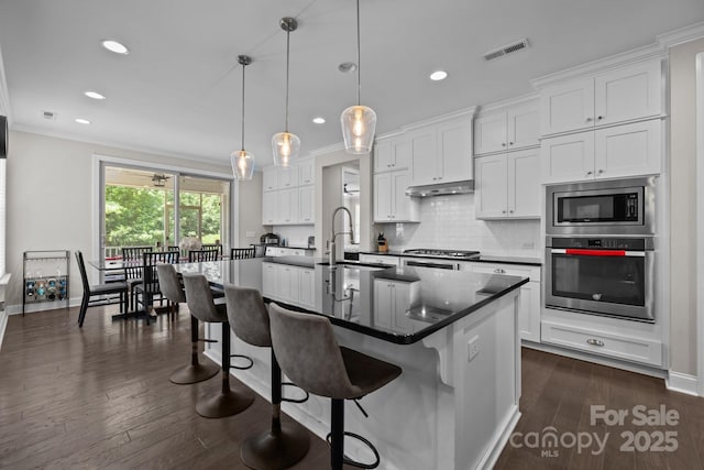 2414 Madeira Cir, Waxhaw, NC 28173 - kitchen featuring appliances with stainless steel finishes, dark countertops, a sink, recessed lighting, and white cabinetry