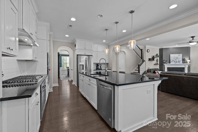 2414 Madeira Cir, Waxhaw, NC 28173 - kitchen with dark countertops, arched walkways, a sink, stainless steel appliances, and recessed lighting