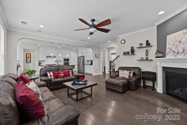 2414 Madeira Cir, Waxhaw, NC 28173 - living area featuring arched walkways, ceiling fan, a glass covered fireplace, dark wood-style flooring, and recessed lighting