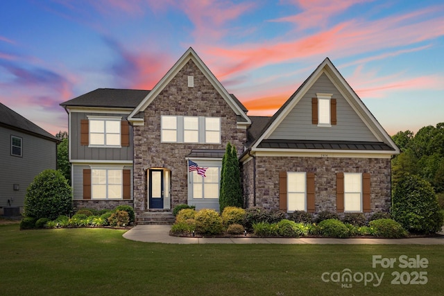 2414 Madeira Cir, Waxhaw, NC 28173 - view of front of house featuring stone siding, a standing seam roof, a front lawn, and central air condition unit
