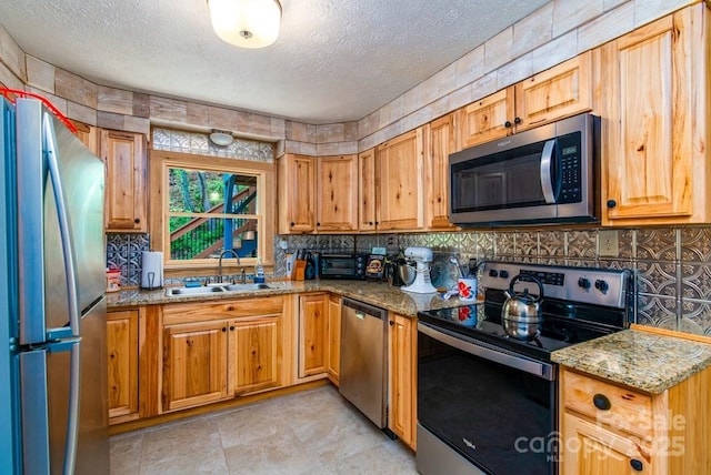 406 Poker Branch Rd, Sylva, NC 28779 - kitchen with appliances with stainless steel finishes, a textured ceiling, a sink, backsplash, and light stone countertops