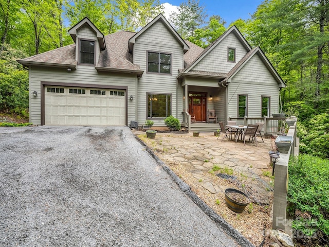 view of front of home featuring roof with shingles, asphalt driveway, and a garage