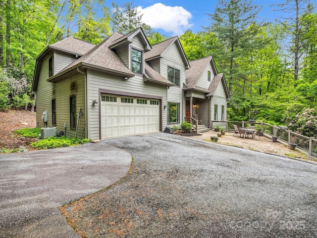 view of front of home with roof with shingles, driveway, and a garage