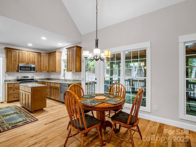 dining room with a chandelier, light wood finished floors, high vaulted ceiling, recessed lighting, and baseboards