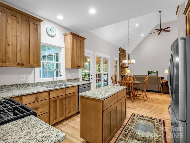 kitchen featuring appliances with stainless steel finishes, a sink, light wood-style floors, recessed lighting, and light stone countertops