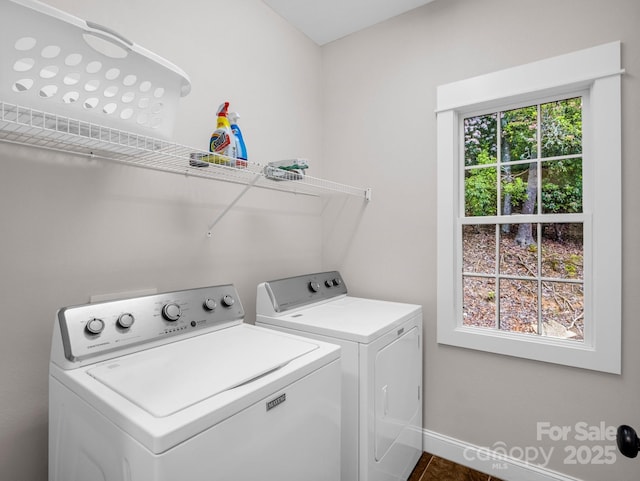 clothes washing area with washing machine and dryer and baseboards