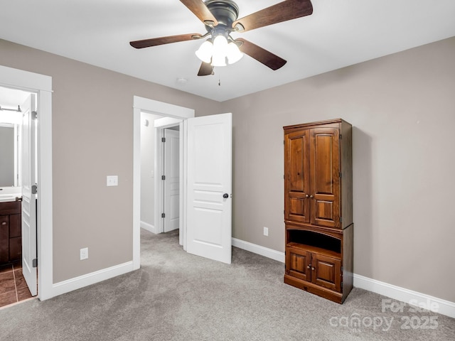 unfurnished bedroom with carpet flooring, baseboards, connected bathroom, and a ceiling fan