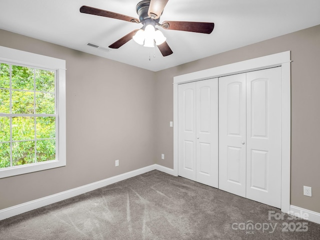 unfurnished bedroom featuring carpet, baseboards, a closet, and a ceiling fan