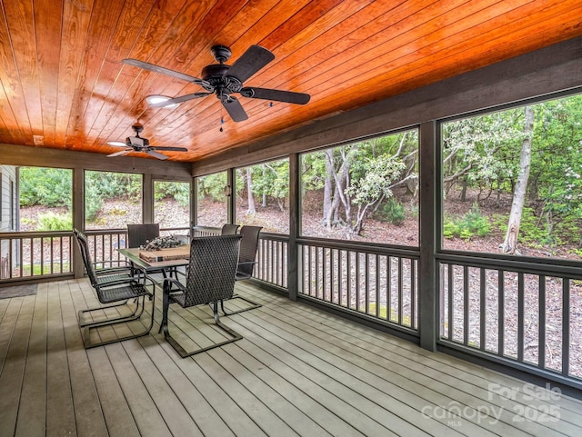 sunroom featuring a ceiling fan, outdoor dining space, and healthy amount of natural light