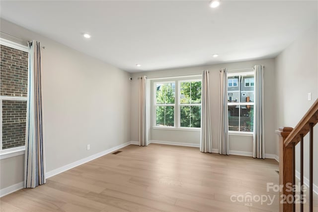 spare room featuring light wood-style flooring, recessed lighting, and baseboards