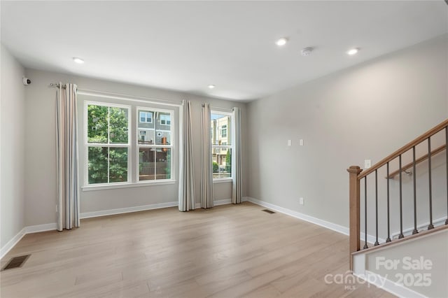 unfurnished room with light wood-type flooring, plenty of natural light, stairway, baseboards, and recessed lighting