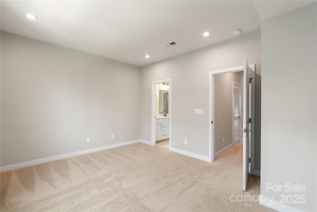 unfurnished bedroom with light colored carpet, baseboards, recessed lighting, and ensuite bathroom