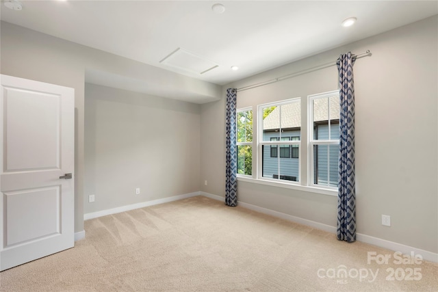 carpeted empty room with baseboards, recessed lighting, and attic access