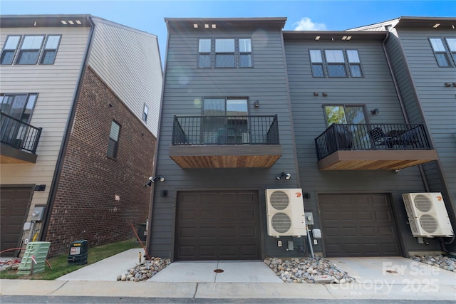 view of building exterior featuring ac unit, a garage, and driveway