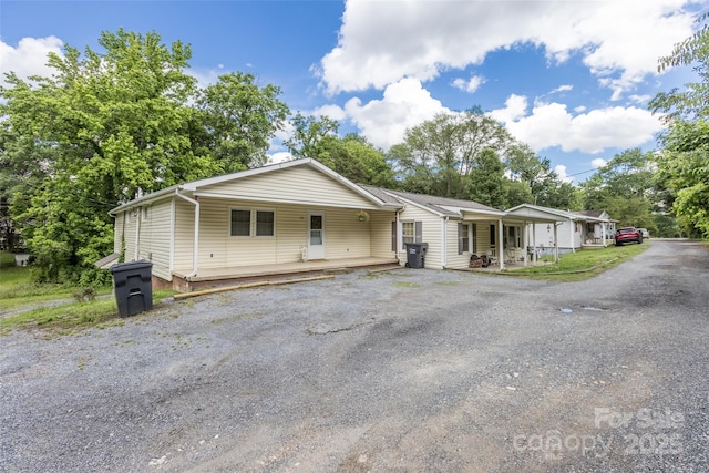 102 Lanier St, Mount Holly, NC 28120 - view of front of house with covered porch, asphalt driveway, and view of scattered trees