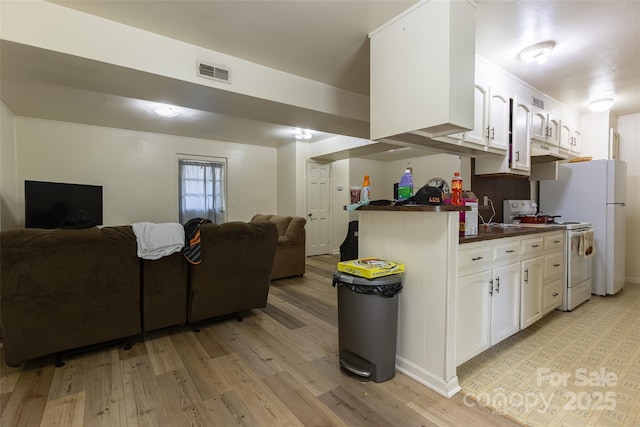 102 Lanier St, Mount Holly, NC 28120 - kitchen with white appliances, open floor plan, dark countertops, light wood finished floors, and white cabinetry