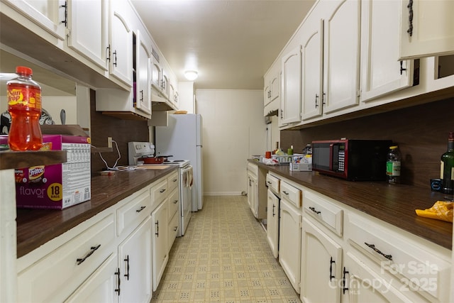 102 Lanier St, Mount Holly, NC 28120 - kitchen with white electric stove, black microwave, white cabinets, light floors, and baseboards