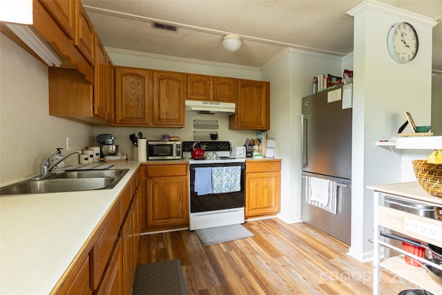 102 Lanier St, Mount Holly, NC 28120 - kitchen with stainless steel appliances, under cabinet range hood, a sink, light wood-style flooring, and brown cabinetry