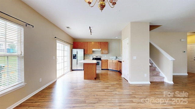 12222 Stratfield Place Cir, Pineville, NC 28134 - kitchen with appliances with stainless steel finishes, under cabinet range hood, light wood finished floors, and light countertops