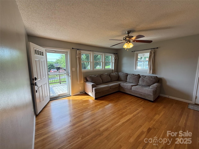 1303 Rambling Acres Cir, Lenoir, NC 28645 - living area with a textured ceiling, light wood-style floors, a ceiling fan, and baseboards