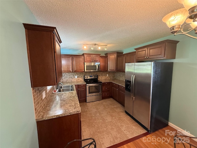 1303 Rambling Acres Cir, Lenoir, NC 28645 - kitchen with stainless steel appliances, a sink, backsplash, a textured ceiling, and light countertops