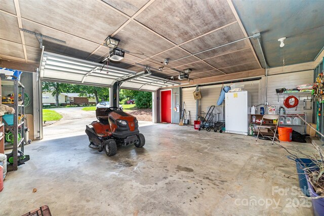 2401 Hoffman St, Gastonia, NC 28054 - garage featuring a garage door opener and freestanding refrigerator