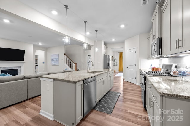 20307 Creek Bend Edge Ct Unit 10, Matthews, NC 28105 - kitchen with appliances with stainless steel finishes, light wood finished floors, open floor plan, pendant lighting, and light stone countertops