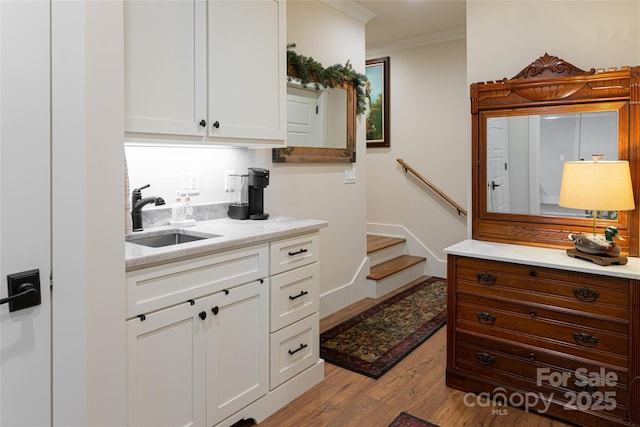 442 Signature Row Blvd, Waynesville, NC 28785 - kitchen featuring a sink, wood finished floors, white cabinets, crown molding, and light stone counters