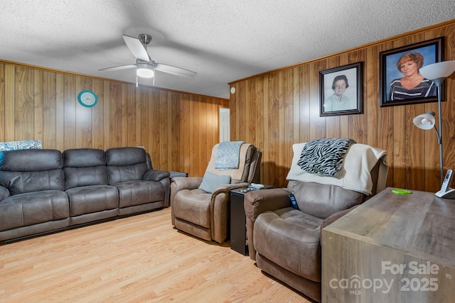 2401 Hillside Dr, Newton, NC 28658 - living room with a textured ceiling, a ceiling fan, wooden walls, wood finished floors, and ornamental molding