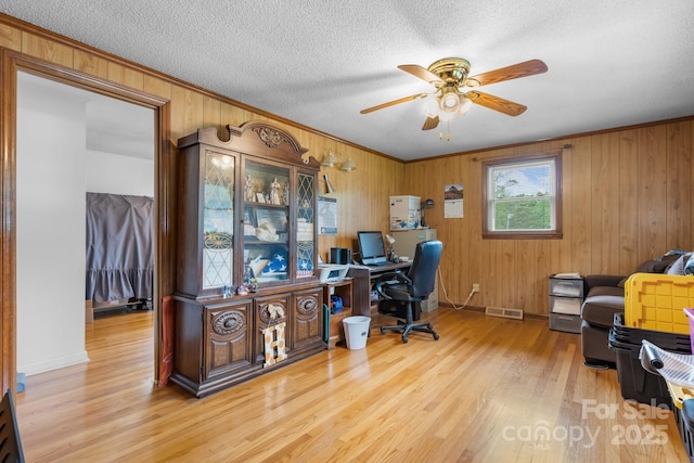 2401 Hillside Dr, Newton, NC 28658 - office with a ceiling fan, light wood-style flooring, wooden walls, crown molding, and a textured ceiling