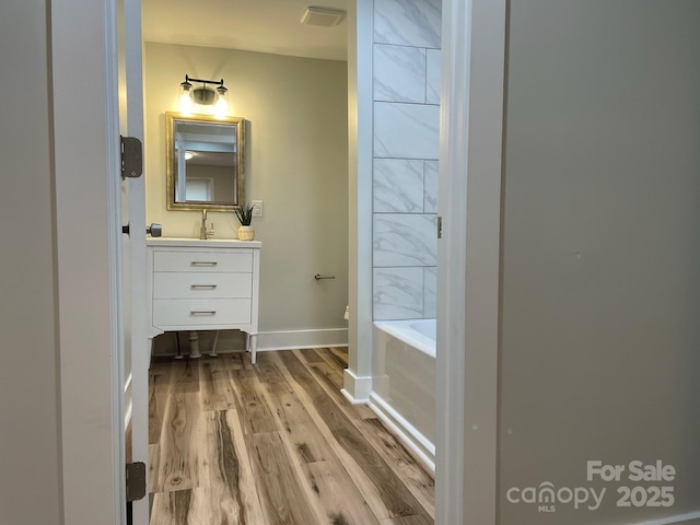 216 N Vance St, Gastonia, NC 28052 - full bathroom with vanity, wood finished floors, and baseboards